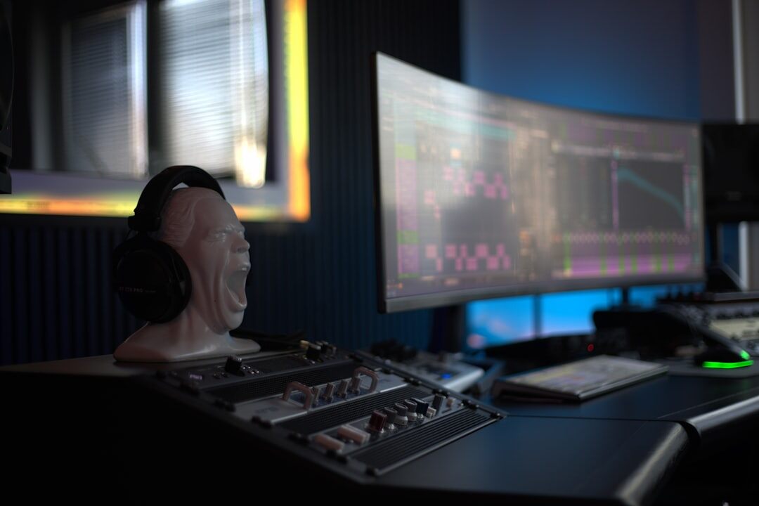 Audio production desk with monitors and waveform displays