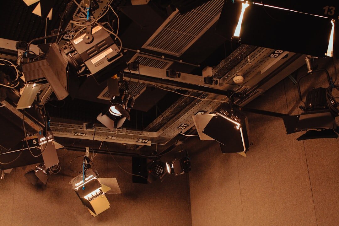 Overhead grid of studio LED lighting fixtures above a TV set
