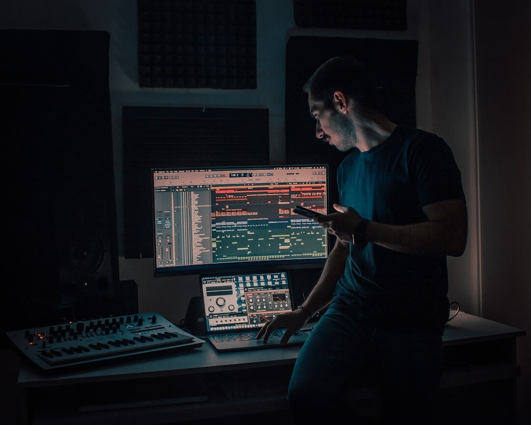 Audio mixing console with sound wave meters glowing in a dark studio
